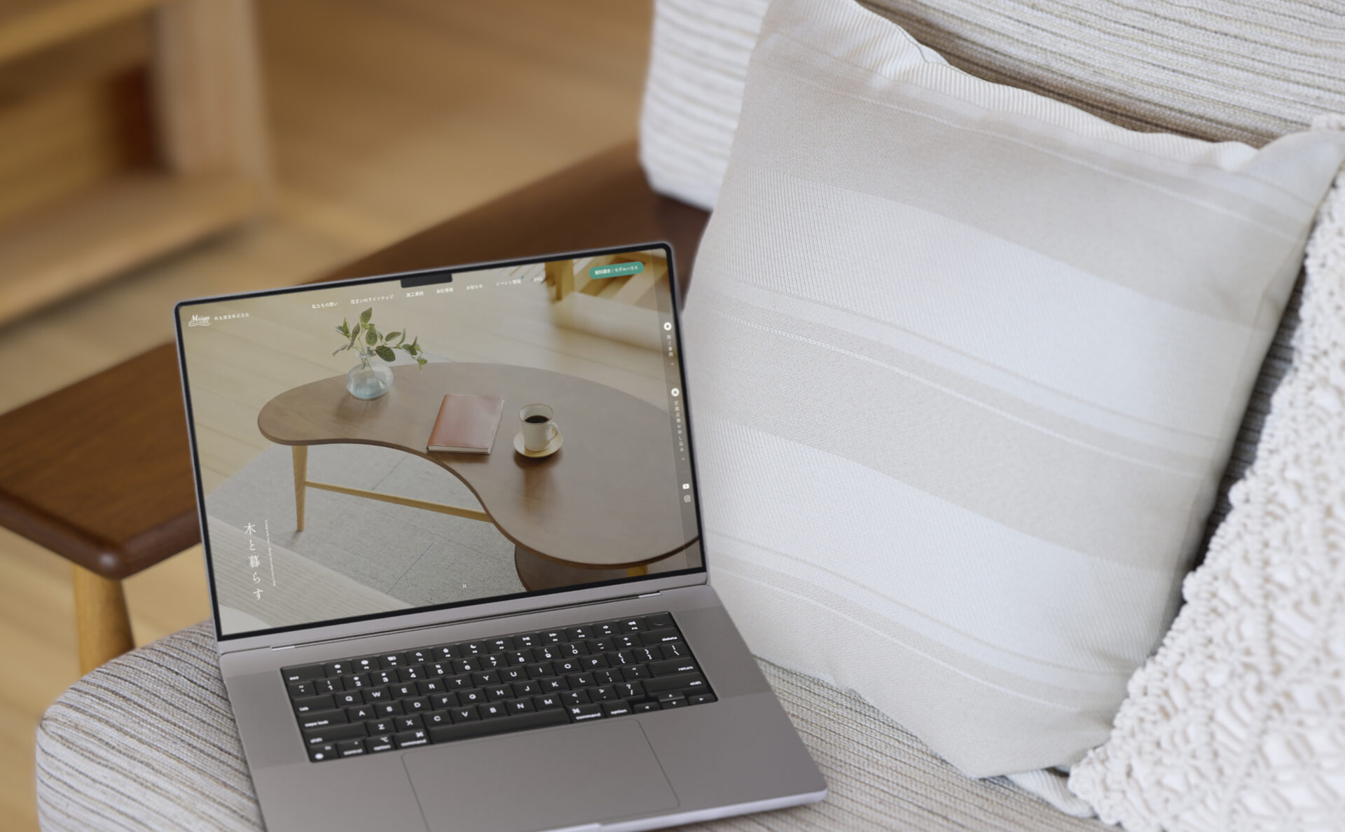 明友建設のコーポレートサイトイメージ、ソファにパソコン